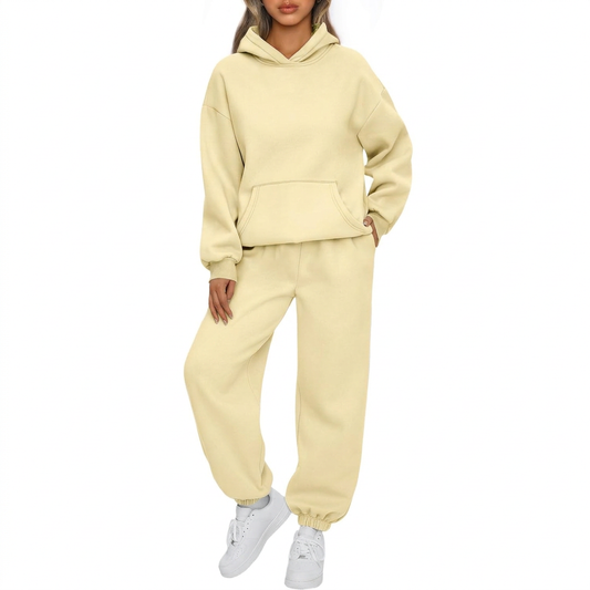 Model wearing a pale yellow AUTOMET fleece hoodie and jogger set on a square white background